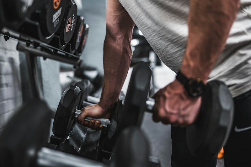 A person picking up a dumbbell for strength training